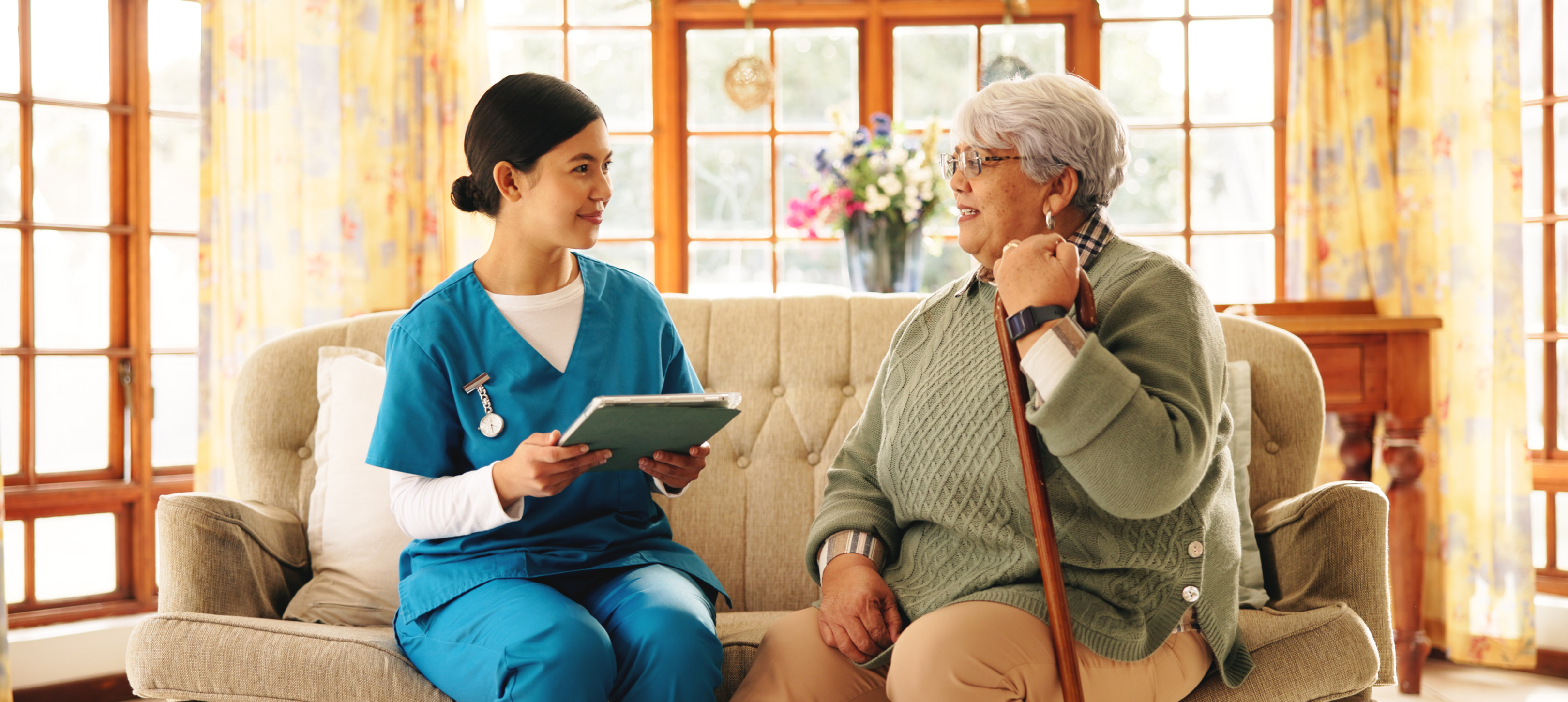 Nurse consulting with elderly woman at home