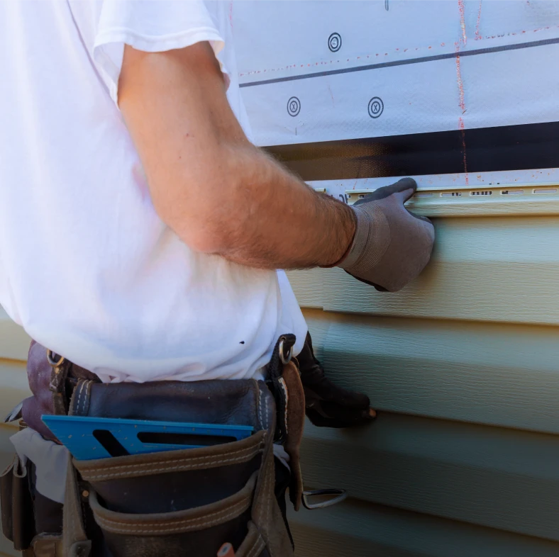 Construction worker measuring siding installation